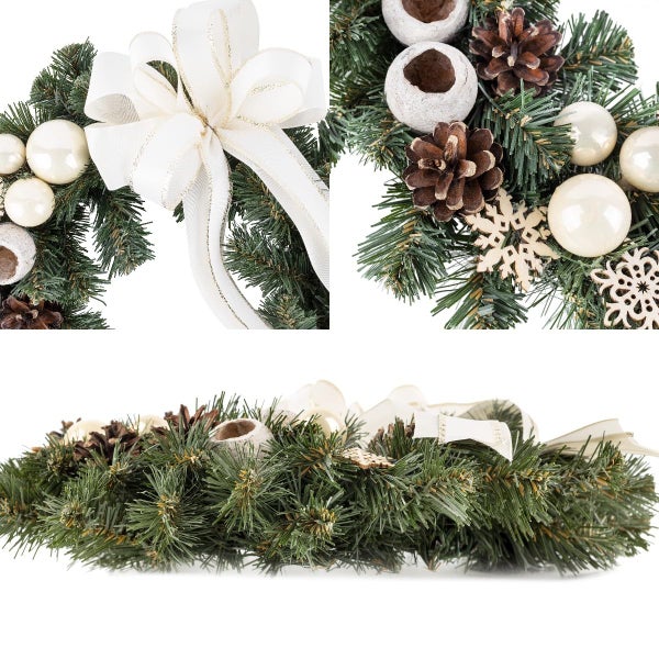 Festlich dekorierter Holztisch mit einem Adventskranz aus künstlichen Tannenzweigen, Zapfen und Kerze sowie Keksen und Teegeschirr.