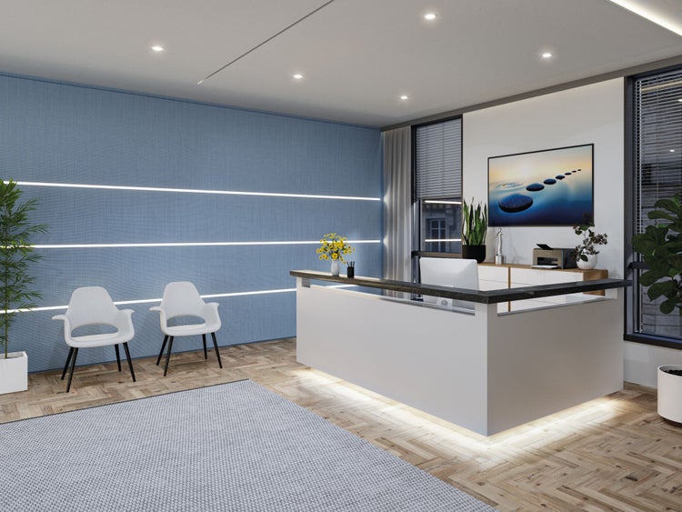 Moderner Empfangsbereich mit weißer Theke, blauer Akzentwand mit LED-Lichtstreifen, zwei weißen Stühlen und Parkettboden.