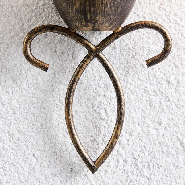 Detail einer Wandleuchte aus Metall mit dekorativem Schnörkel in Antik-Optik.