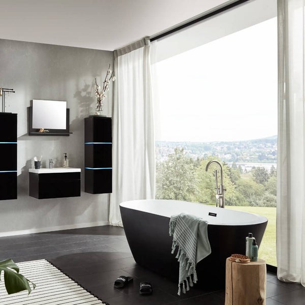 Modernes Badezimmer mit freistehender Wanne, Waschtisch mit beleuchteten Badmöbeln und großem Fenster mit Blick in die Natur.
