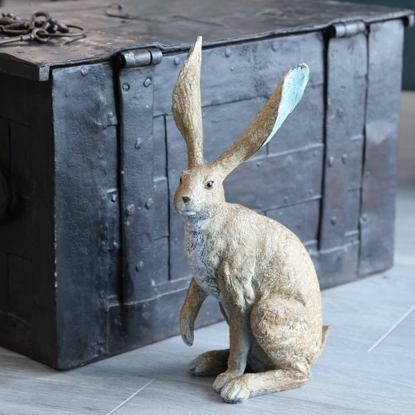 Dekorative Hasenfigur vor einer Truhe