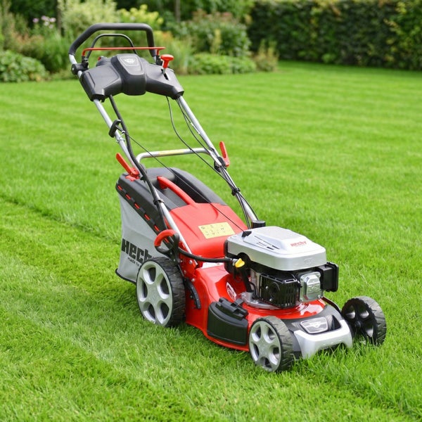 Benzin-Rasenmäher von Hecht mit Grasfangkorb auf einer grünen Rasenfläche.