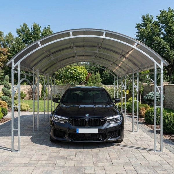 Rundbogen-Carport aus verzinktem Stahl mit Polycarbonat-Eindeckung, ein Fahrzeug steht auf einer gepflasterten Fläche unter dem Dach.