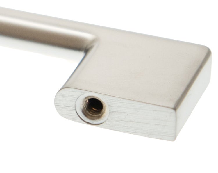 Detailansicht eines silberfarbenen Möbelgriffs mit Schraubloch