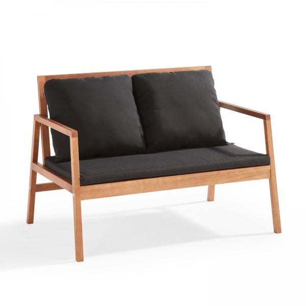 Gartensessel aus Holz mit schwarzen Sitz- und Rückenkissen.