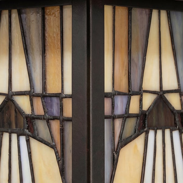 Nahaufnahme eines Glasmosaiks mit geometrischen Mustern in einer dunklen Fassung.