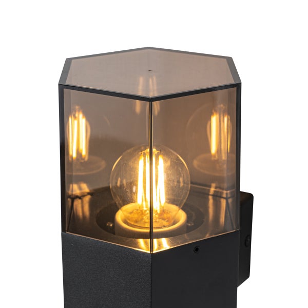 Sechseckige Außenwandleuchte mit getöntem Glas und sichtbarem Filament-Leuchtmittel.