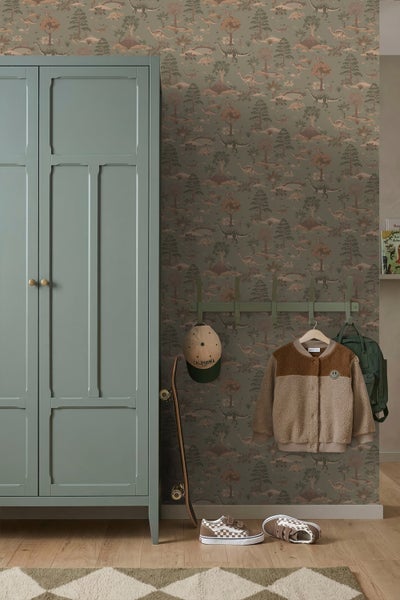 Tapete mit Dinosaurier-Motiv im prähistorischen Stil in einem Kinderzimmer mit Kleiderschrank, Garderobe und Skateboard.