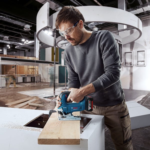 Im Korb wachsender Strauch vor einer Backsteinmauer