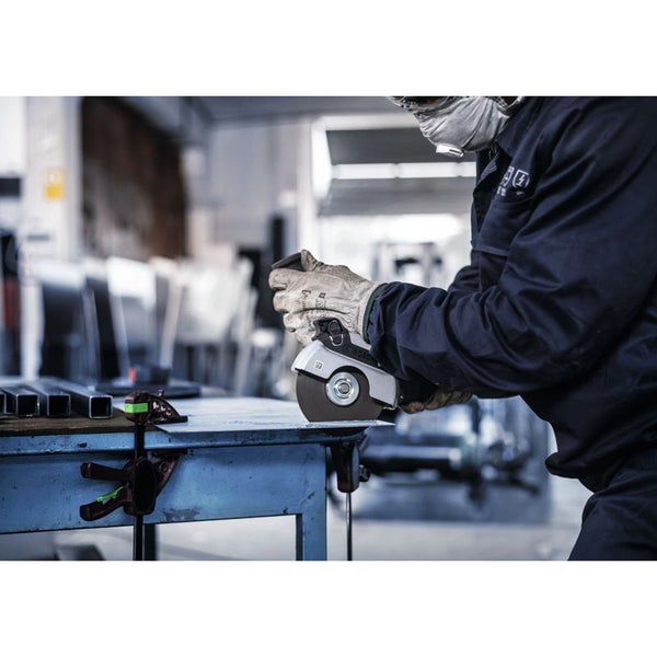 Eine Person mit Schutzbrille, Atemschutz und Handschuhen benutzt eine Trennschleifmaschine zum Schneiden von Metall auf einer Werkbank.