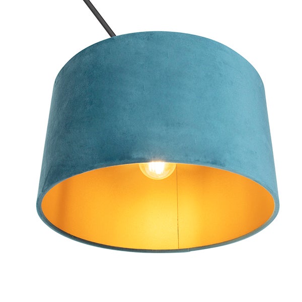Pendelleuchte mit blauem Samtschirm und goldfarbener Innenseite.