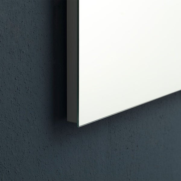 Detailansicht der Kante eines flachen Wandspiegels an einer strukturierten Wand.