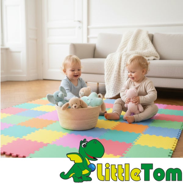 Zwei Kleinkinder spielen auf einer bunten Puzzle-Spielmatte aus Schaumstoff in einem hellen Wohnzimmer. Unten rechts ist das LittleTom Logo.