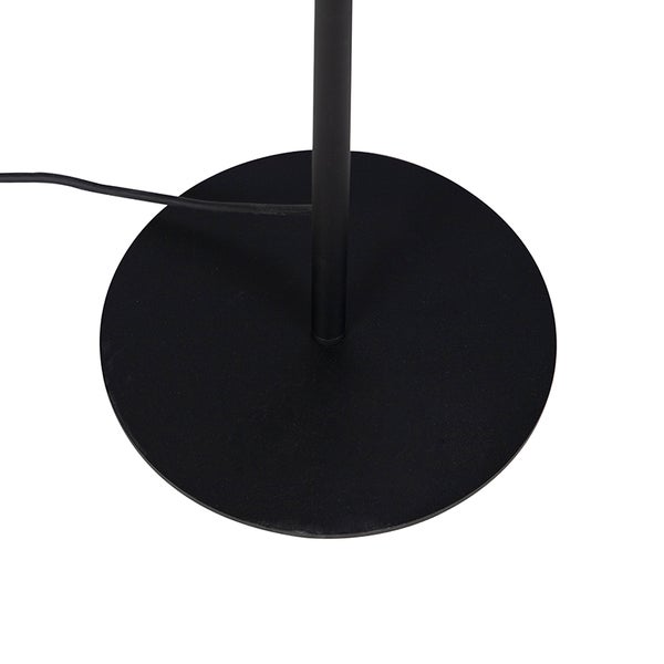 Runder Standfuß einer schwarzen Stehlampe mit Netzkabel.