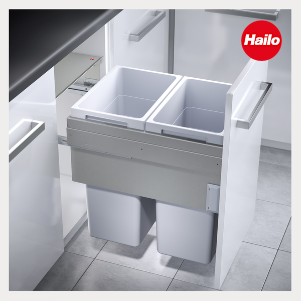 Hailo Logo. Ausziehbarer Abfallsammler mit zwei Behältern in einem weißen Küchenunterschrank mit Metallgriffen.