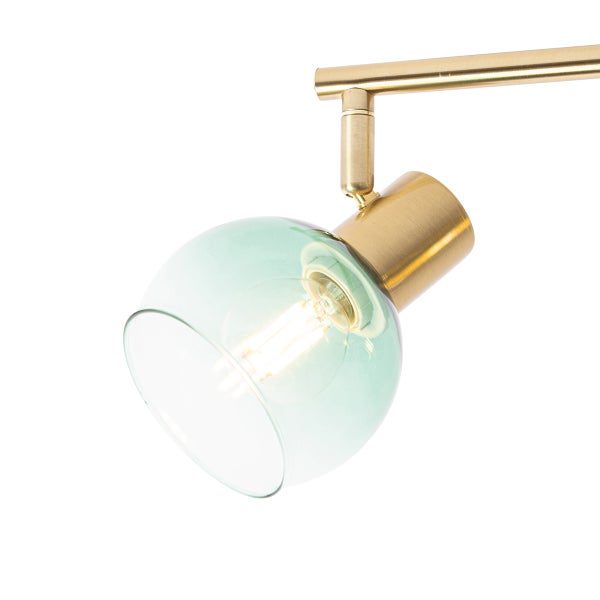 Detailaufnahme einer Wandleuchte mit grünem Glasschirm und Messingfassung