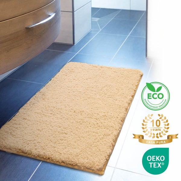 Beige Badematte vor einem Waschtisch mit den Siegeln ECO, 10 Jahre Casa Pura Garantie und OEKO-TEX