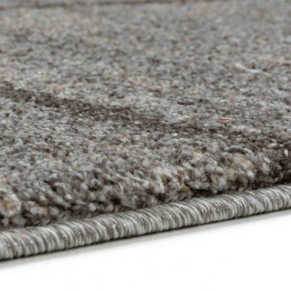 Nahaufnahme eines melierten grau-braunen Teppichs mit geketteltem Rand.