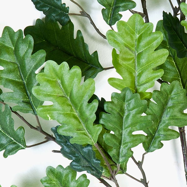 Künstliche Eichenblätter an Zweigen in verschiedenen Grüntönen.