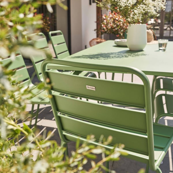 Gartenmöbel aus grünem Metall mit Lattenstühlen und Tisch auf einer hellen Terrasse, mit Oviala Logo