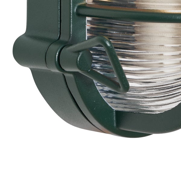 Detailansicht einer dunkelgrünen ovalen Außenwandleuchte aus Metall mit geripptem Glasdiffusor.