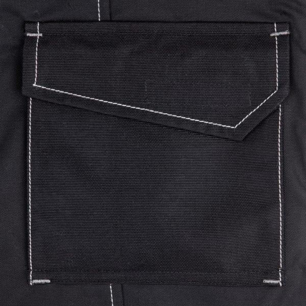 Nahaufnahme einer aufgesetzten Tasche mit Taschenklappe und Kontrastnähten an einer Arbeitshose.