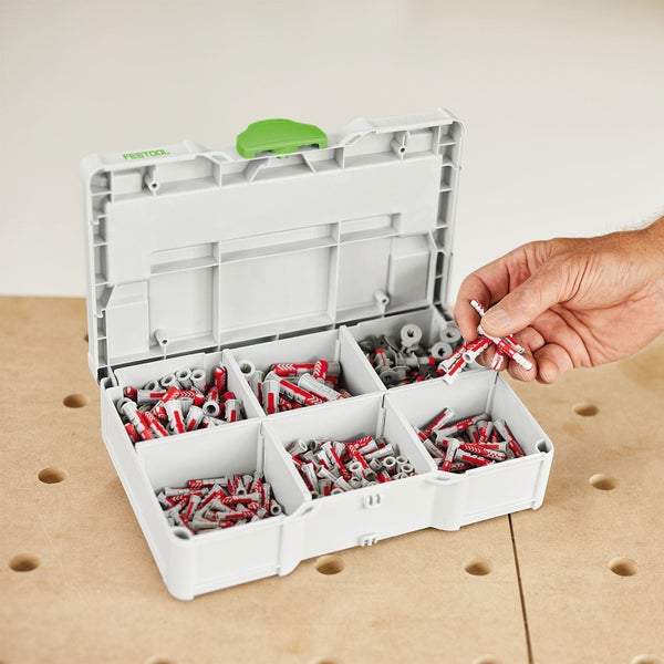 Festool Systainer Rack mit kleinen Koffern auf einer Werkbank. Eine Person zieht einen Koffer heraus. Mit Festool Logo und Erste-Hilfe-Symbol.