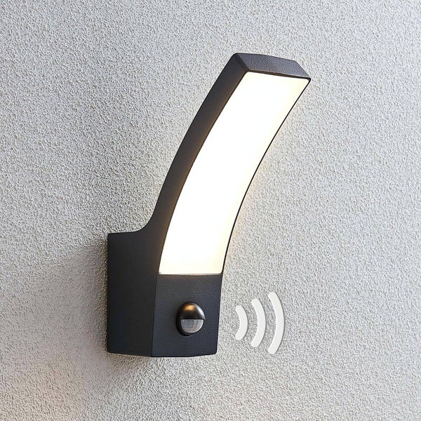 Moderne Außenwandleuchte in Anthrazit mit integriertem Bewegungsmelder und gebogener LED-Leuchtfläche an einer Hauswand.