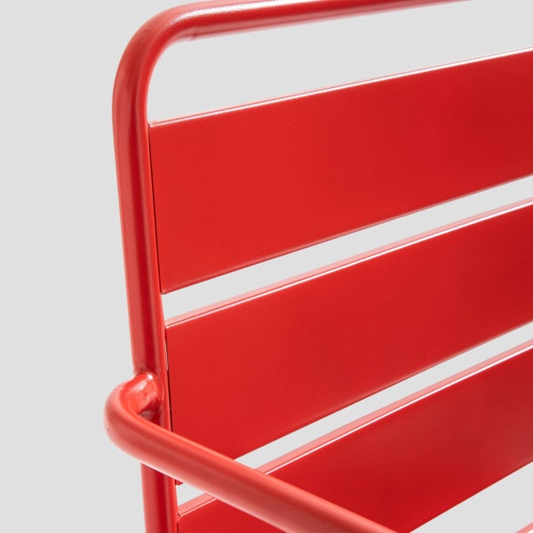 Detailansicht der roten Rückenlehne eines Gartenstuhls aus Metall mit horizontalen Lamellen.