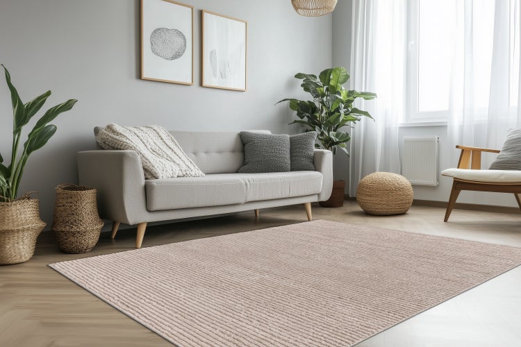 Wohnzimmer mit beigem Teppich, Sofa, Korbmöbeln und Pflanzen in einem hellen, skandinavisch eingerichteten Raum.
