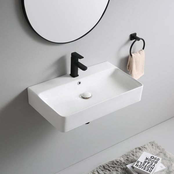 Modernes wandhängendes rechteckiges Waschbecken mit schwarzer Einhebelarmatur, Rundspiegel und Handtuchring im Badezimmer.