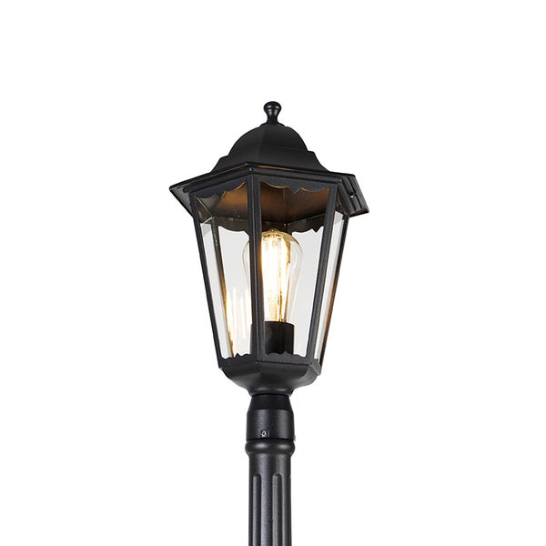 Klassische Wegeleuchte aus Metall in Schwarz mit klarem Glas und brennendem Leuchtmittel.