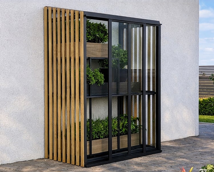 Modernes Anlehn-Gewächshaus mit schwarzem Metallrahmen und vertikalen Holzlatten, bestückt mit Pflanzkästen an einer hellen Hauswand.