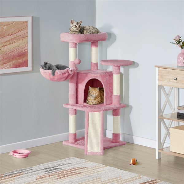 Rosa Katzenkratzbaum mit Liegeflächen und Kratzstamm im Wohnzimmer mit drei Katzen.