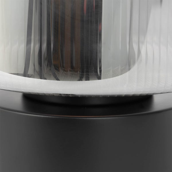 Detailaufnahme einer Leuchte mit geriffeltem Lampenschirm und schwarzem Sockel