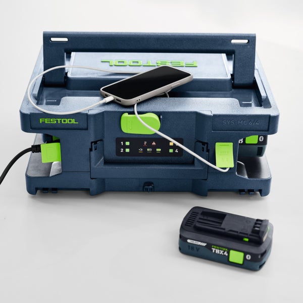 Festool Systainer-Ladestation SYS-MC 6/4 lädt ein Smartphone über USB-C, mit einem 18-Volt-Akkupack im Vordergrund.