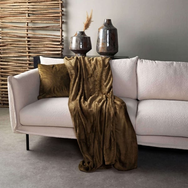 Wohnzimmer-Szene mit Sofa, Kissen, Decke und dekorativen Vasen