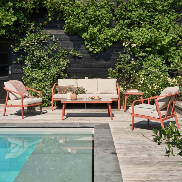 Modernes Garten-Lounge-Set aus Metall mit Sofa, zwei Sesseln und Couchtisch auf einer Holzterrasse neben einem Pool.