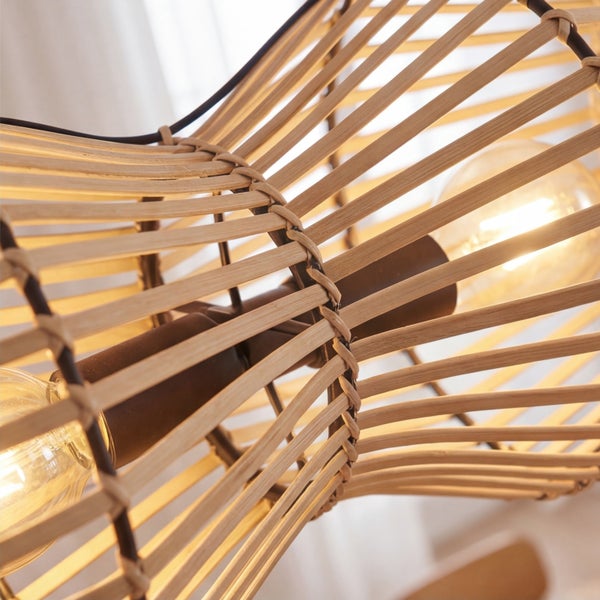 Nahaufnahme einer Pendelleuchte mit einem Schirm aus Naturholzlamellen und leuchtenden Leuchtmitteln.