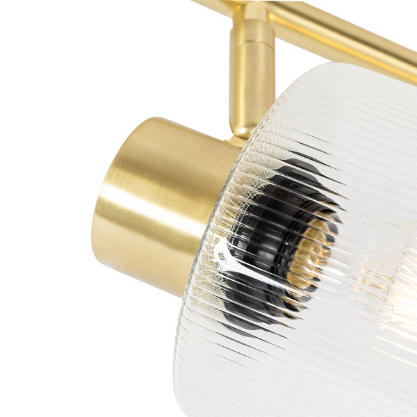 Nahaufnahme einer goldenen Lampe mit geriffeltem Glasschirm
