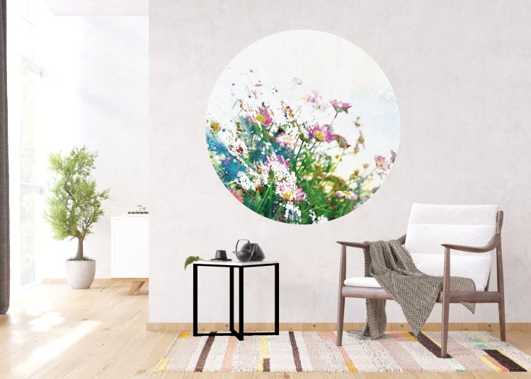 Wohnzimmer mit rundem Wandbild von Blumen, Sessel und Beistelltisch