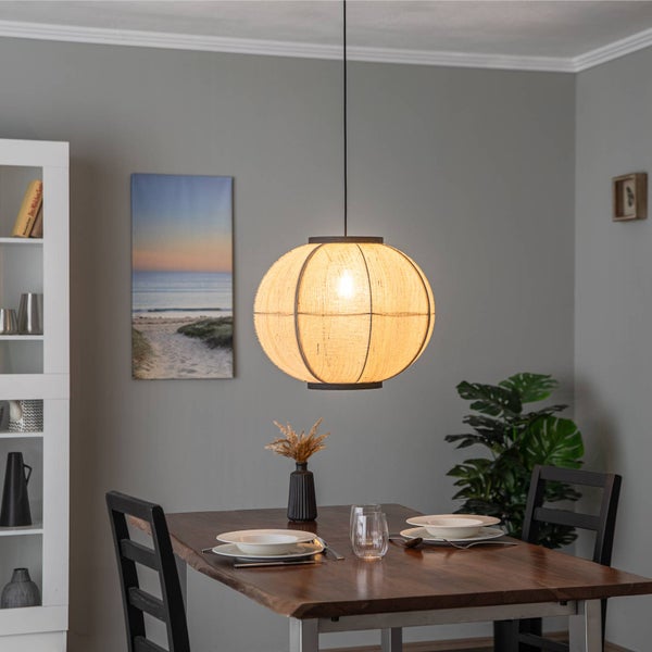Runde Pendelleuchte mit Schirm aus beigem Textilgewebe über einem gedeckten Holztisch in einem modern eingerichteten Esszimmer.