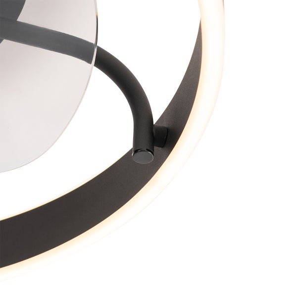 Detail einer modernen schwarzen LED-Leuchte mit integriertem Lichtring und transparentem dekorativem Element.