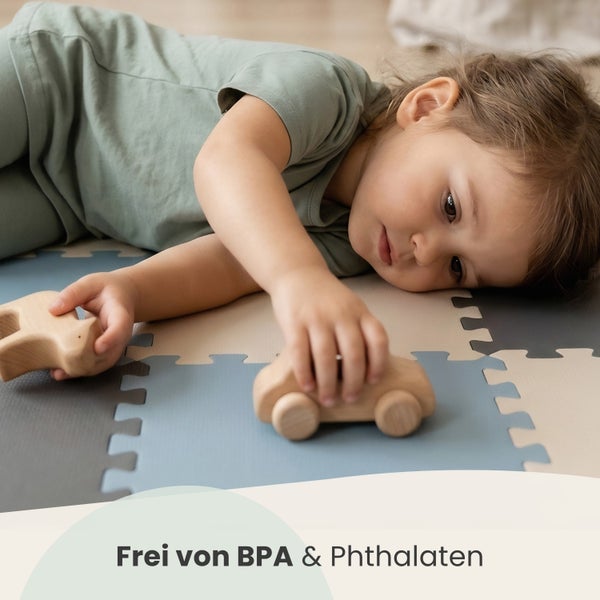 Kind spielt mit Holzspielzeug auf einer Puzzlematte, frei von BPA und Phthalaten.