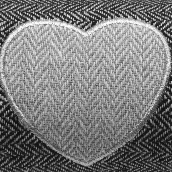 Nahaufnahme eines Herzens aus Stoff mit Fischgrätenmuster