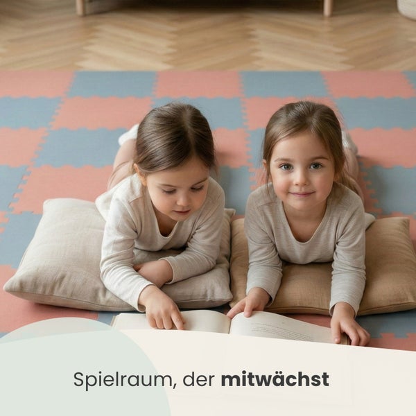 Zwei Kinder lesen ein Buch auf einer Spielmatte in einem hellen Spielzimmer.