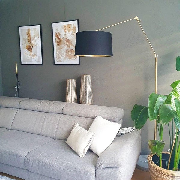 Wohnzimmer mit Sofa, Stehlampe, Vasen und gerahmten Bildern