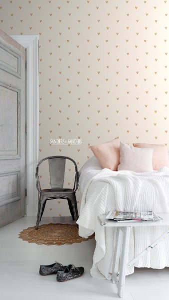 Ein Schlafzimmer mit einer Wandtapete mit Herzmuster, einem Bett mit Kissen, einem Stuhl und Schuhen.