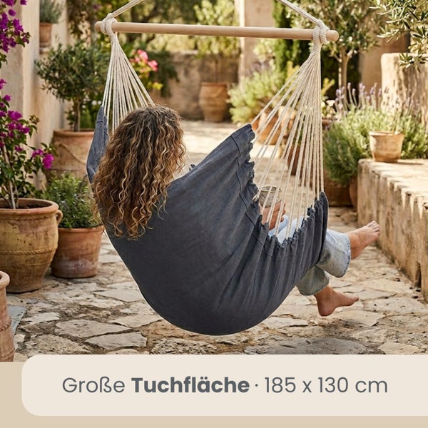 Hängesessel mit großer Tuchfläche von 185 mal 130 Zentimetern und Holzstab in einem mediterranen Garten.