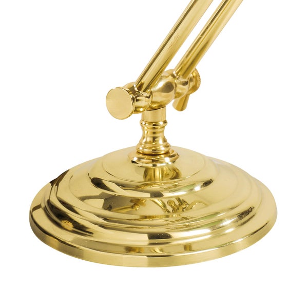 Detailaufnahme des goldenen Lampenfußes einer Schreibtischlampe.